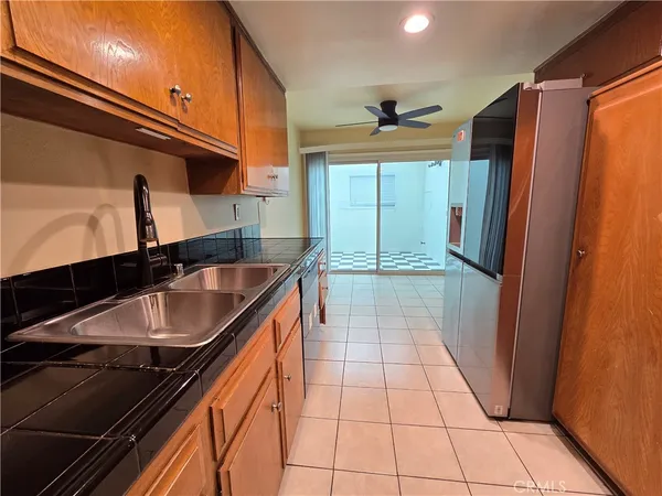 a kitchen with granite countertop a sink stove and refrigerator