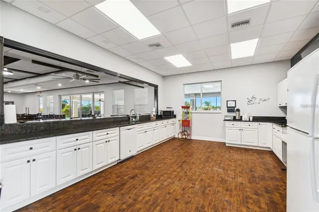 a large white kitchen with sink and cabinets