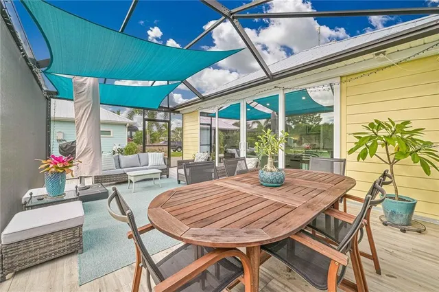 a view of a patio with table and chairs potted plants with floor to ceiling window