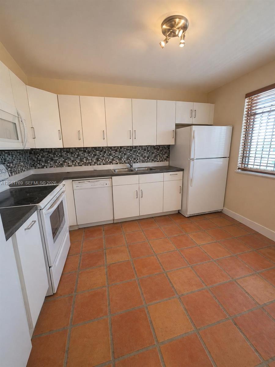 286 Racquet Club Road, Unit 204 Weston, FL 33326 - Photo 5 of 11 a kitchen with a sink a stove cabinets and a counter top space