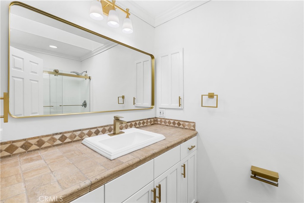 26096 Adamor Road Calabasas, CA 91302 - Photo 49 of 61 Family bathroom with oversized kitchen cabinets and tumbled turkish stone flooring and counter.