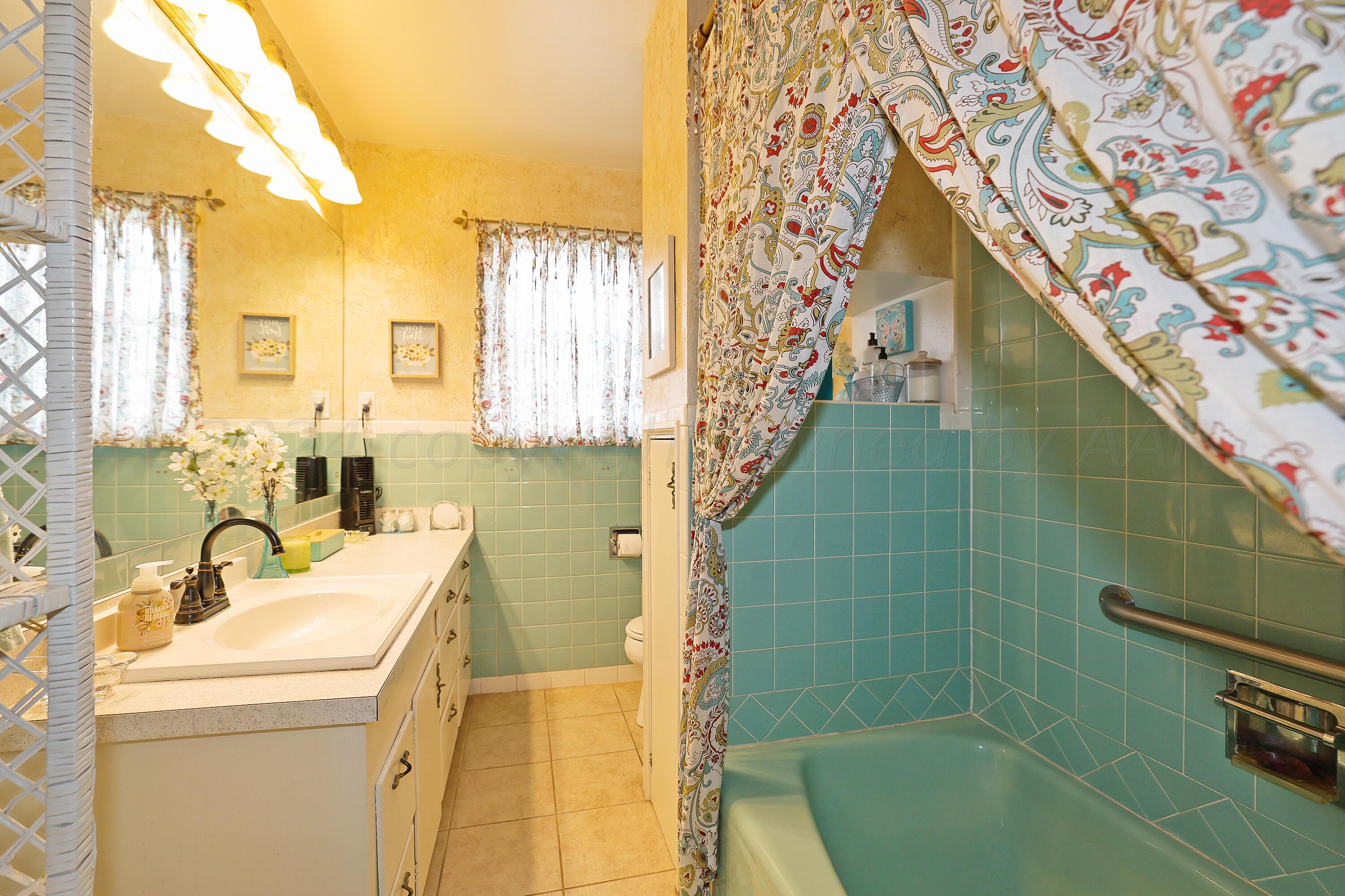 411 North Prospect Street Amarillo, TX 79106 - Photo 13 of 22 a bathroom with a sink and mirror with bathtub