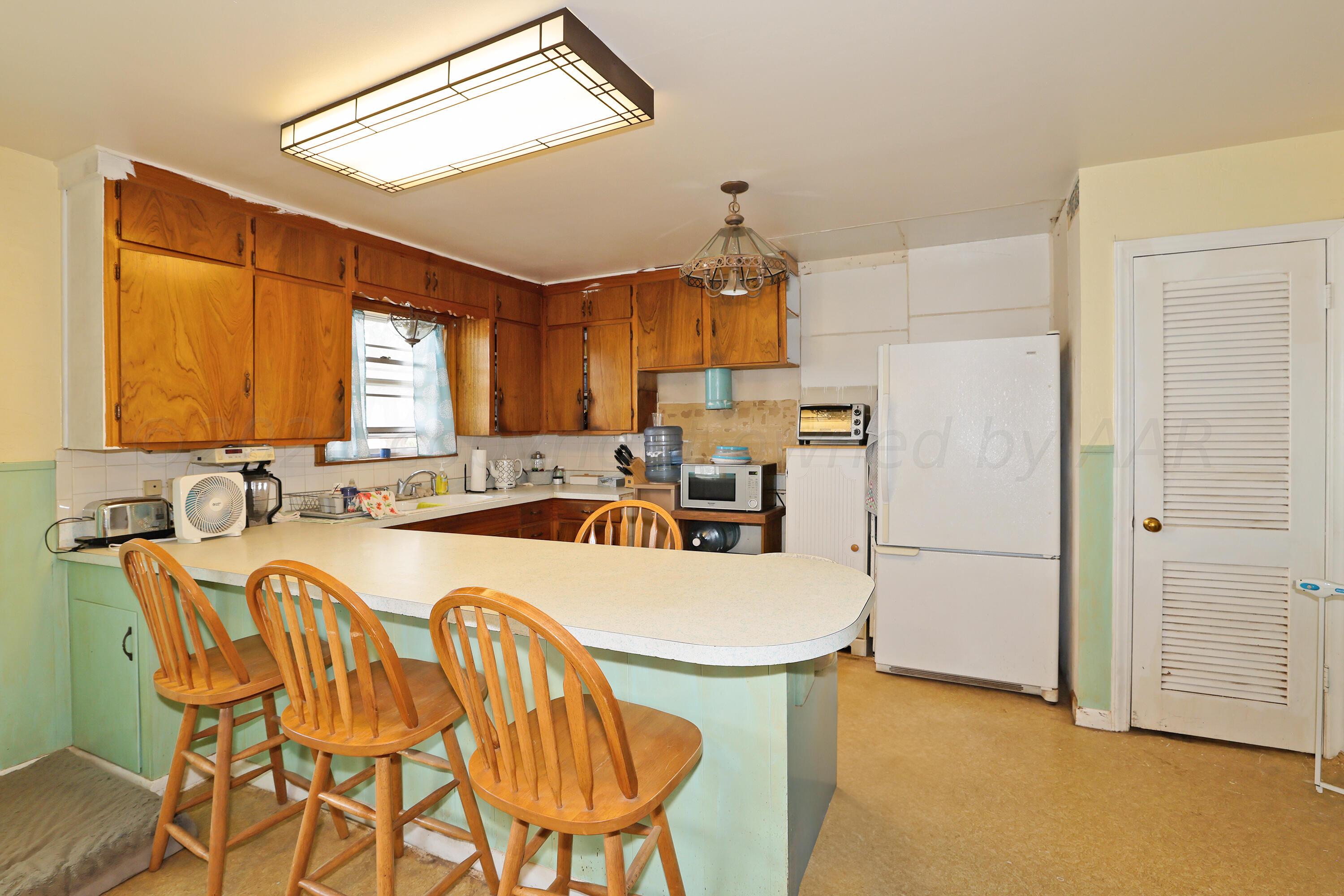 411 North Prospect Street Amarillo, TX 79106 - Photo 8 of 22 a kitchen with a table chairs refrigerator and microwave