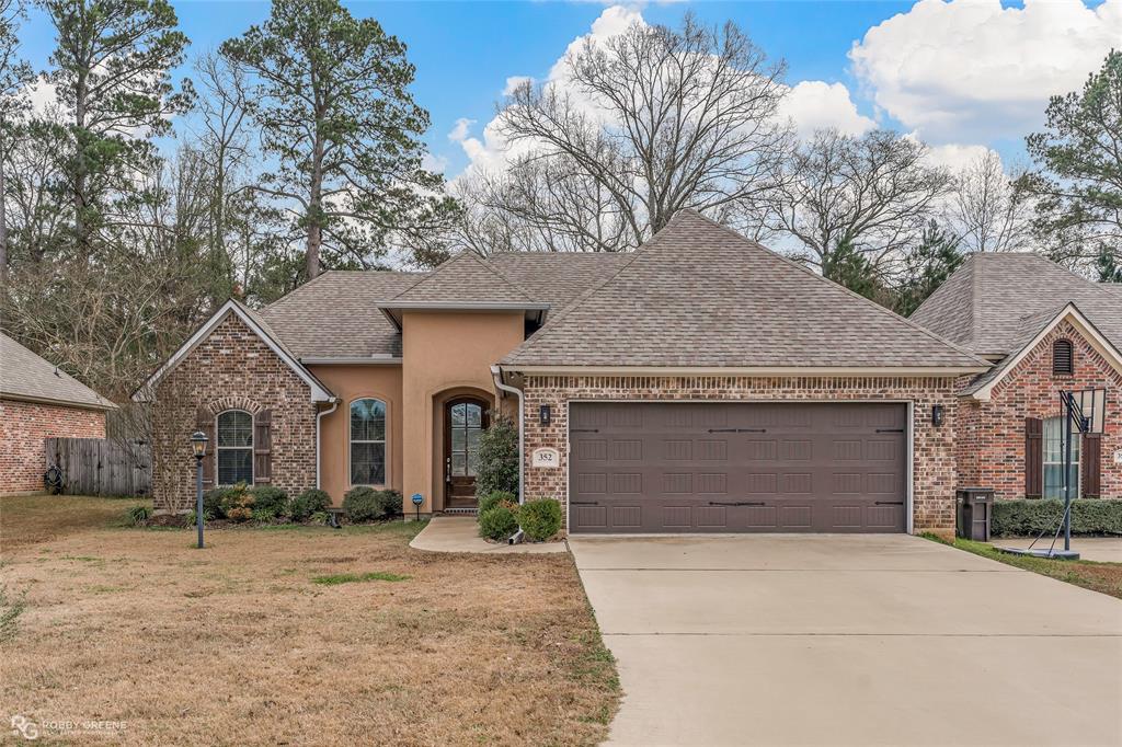 352 Wood Springs Haughton, LA 71037 - Photo 1 of 34 a front view of a house with a yard and garage