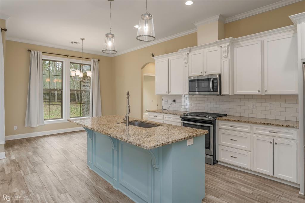 352 Wood Springs Haughton, LA 71037 - Photo 13 of 34 a kitchen with stainless steel appliances granite countertop a stove a sink and white cabinets