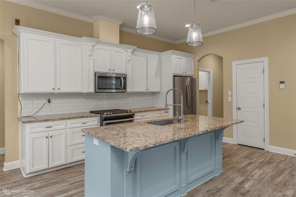 352 Wood Springs Haughton, LA 71037 - Photo 18 of 34 a kitchen with granite countertop a sink a counter top space cabinets and stainless steel appliances