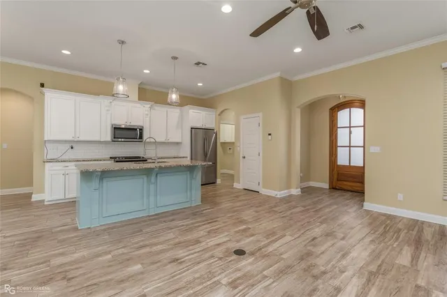 a view of kitchen with cabinets appliances wooden floor and window