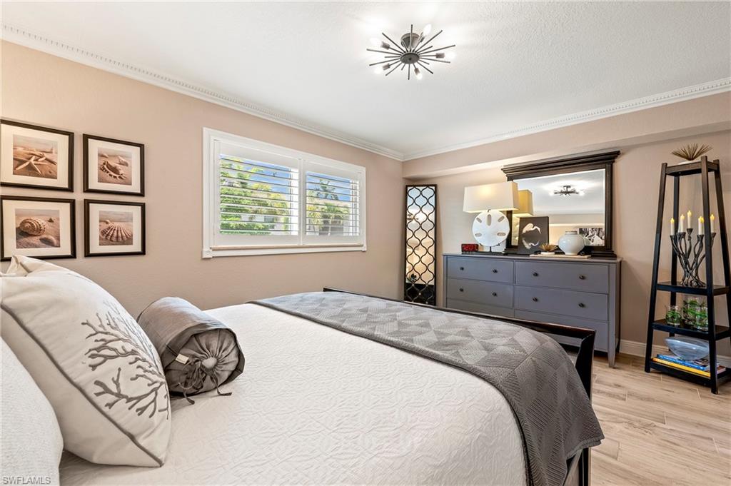 950 7th Avenue South, Unit 23 Naples, FL 34102 - Photo 13 of 40 a spacious bedroom with a bed dresser and a window
