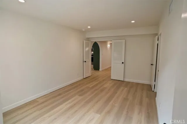 a view of an empty room with wooden floor