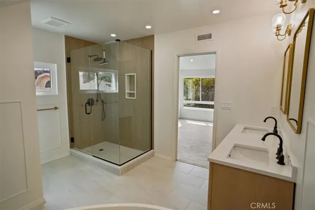 a bathroom with a granite countertop sink a mirror and shower