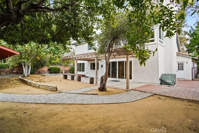 a view of a house with backyard and tree
