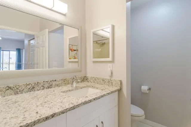 a bathroom with a granite countertop sink and a mirror