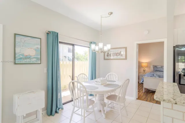a view of a dining room with furniture a chandelier and a large window