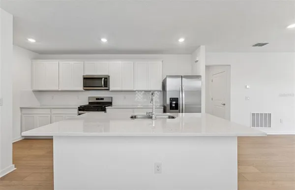 a kitchen with stainless steel appliances a refrigerator sink stove microwave and cabinets