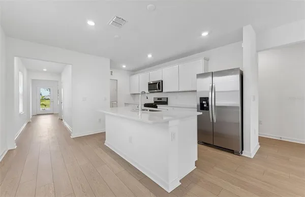 a kitchen with stainless steel appliances granite countertop a refrigerator and a stove top oven