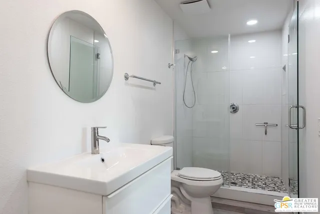 a bathroom with a sink a toilet and a mirror