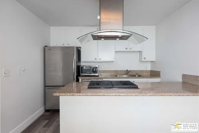 a kitchen with granite countertop a refrigerator stove and sink