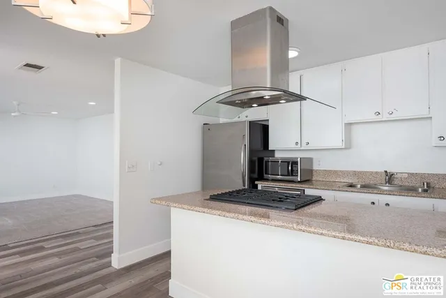 a kitchen with kitchen island a sink stainless steel appliances and cabinets