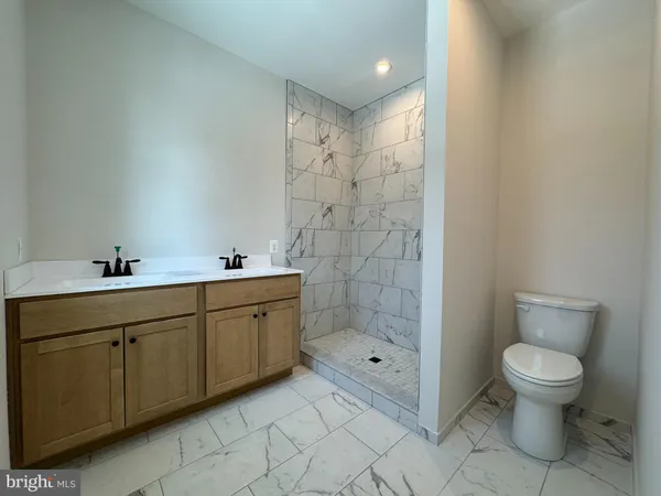 a bathroom with a double vanity sink toilet and shower