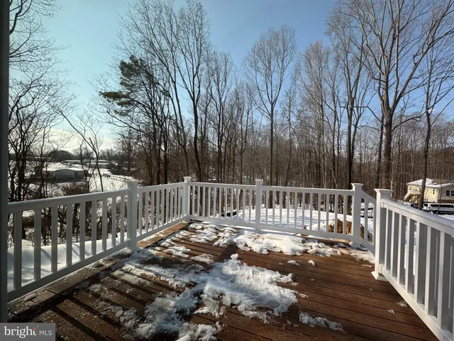 a view of deck with wooden fence and trees