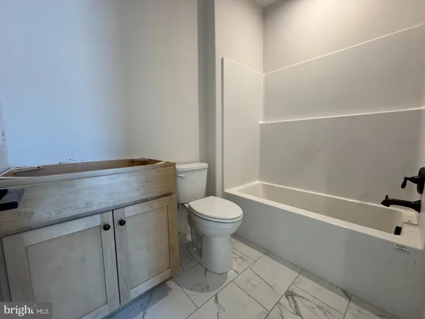 a bathroom with a granite countertop toilet sink and mirror