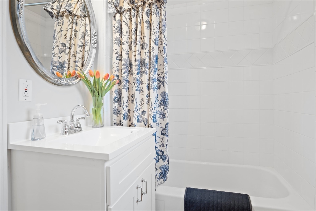 8 Flagg Street Woburn, MA 01801 - Photo 12 of 25 a bathroom with a sink a mirror and a shower