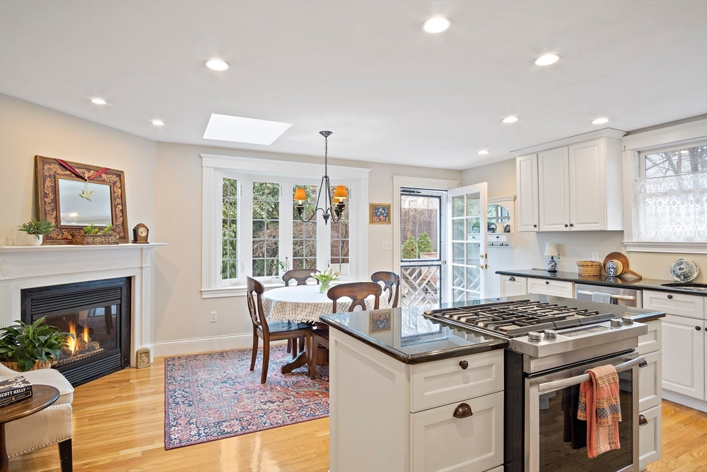8 Flagg Street Woburn, MA 01801 - Photo 3 of 25 a kitchen with granite countertop a stove top oven a sink dishwasher a dining table and chairs with wooden floor
