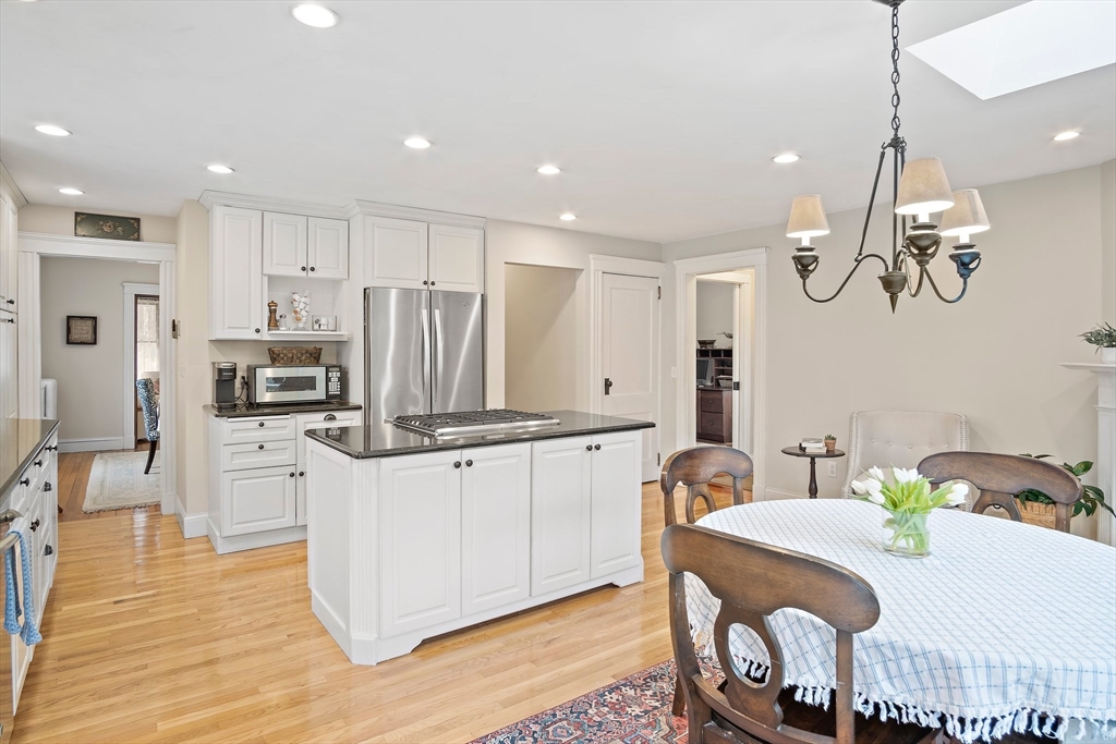 8 Flagg Street Woburn, MA 01801 - Photo 5 of 25 a kitchen with stainless steel appliances kitchen island granite countertop a table chairs and a refrigerator