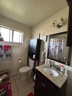 a bathroom with a granite countertop toilet sink and mirror
