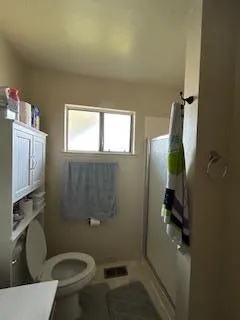 a bathroom with a granite countertop toilet and a sink