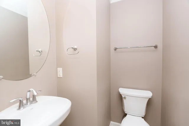 a white toilet sitting next to a bathroom sink