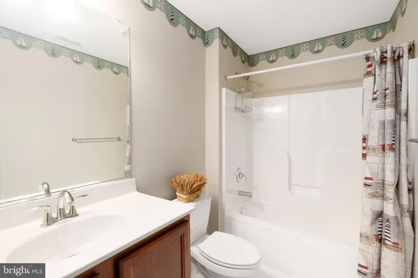 a bathroom with a sink a toilet a mirror and a shower
