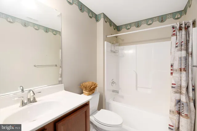 a bathroom with a sink a toilet a mirror and a shower