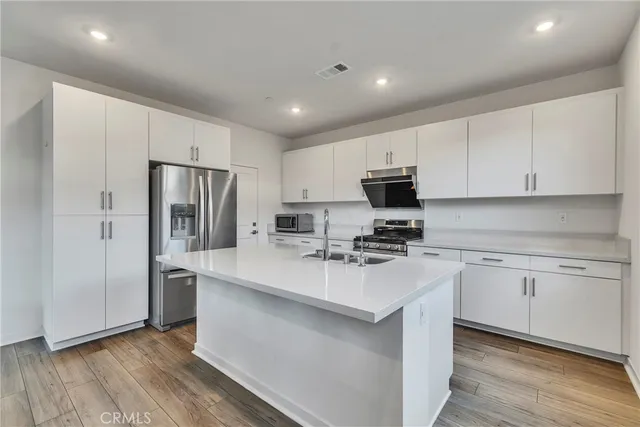 a kitchen with refrigerator cabinets and wooden floor