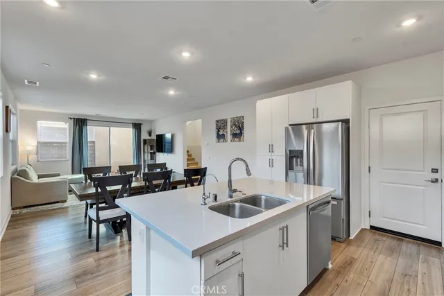 a kitchen with stainless steel appliances a sink a table and chairs