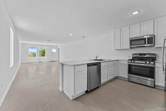 a kitchen with granite countertop white cabinets and stainless steel appliances