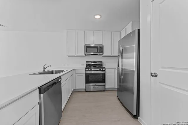 a kitchen with granite countertop a refrigerator and a stove