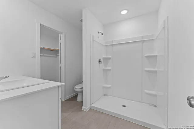 a bathroom with a shower a toilet and sink