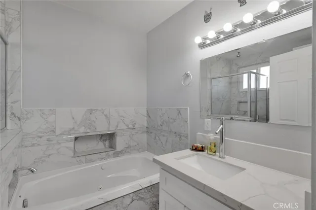 a bathroom with a sink a bathtub and a mirror