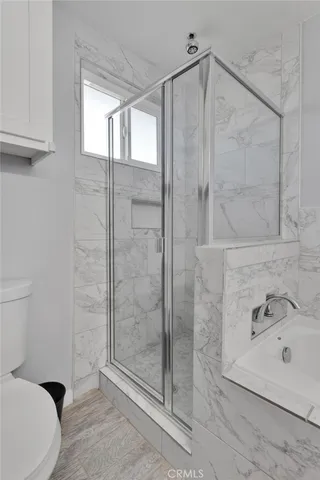 a bathroom with a shower a toilet and sink