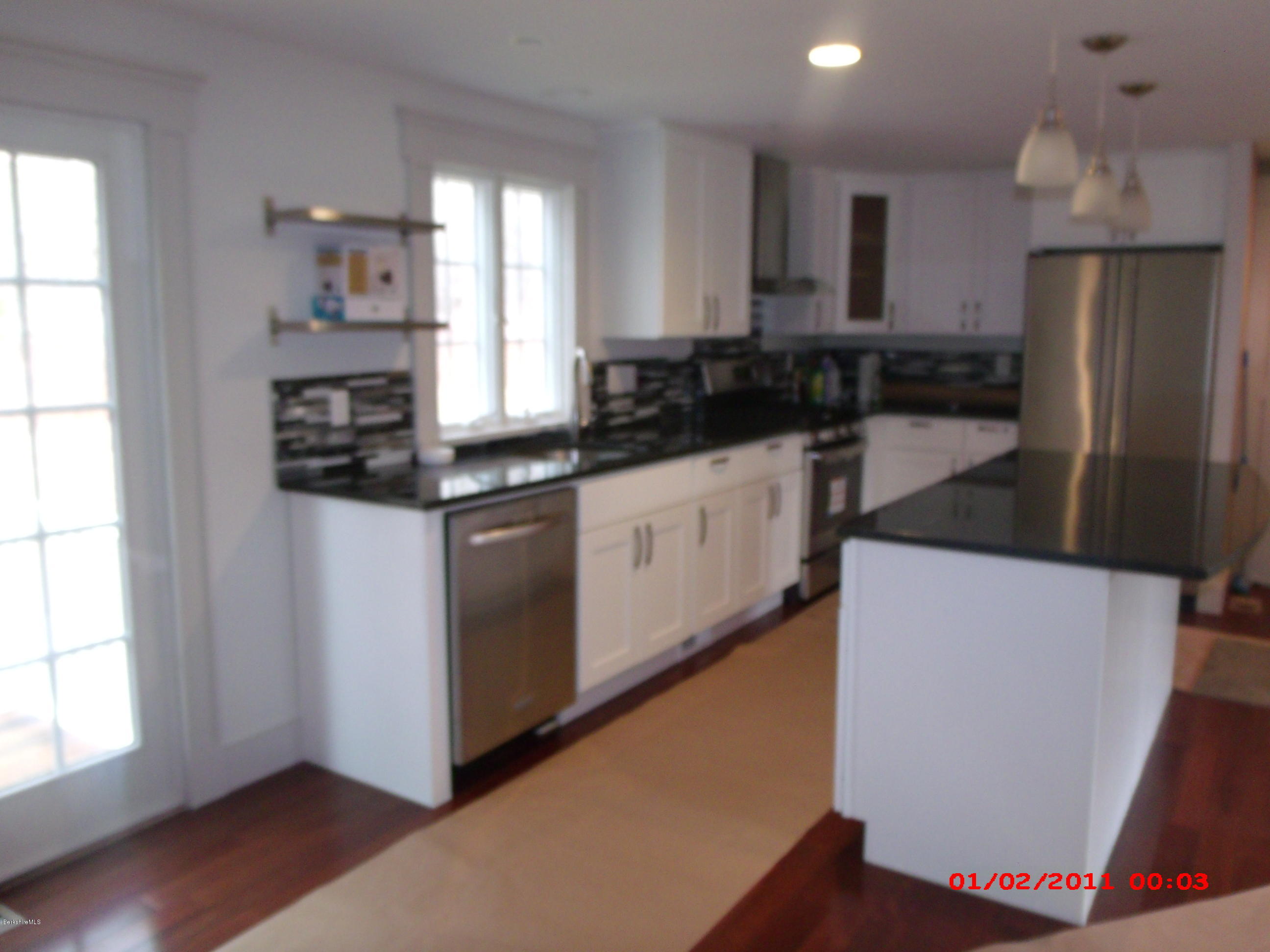 2986 State Road Richmond, MA 01254 - Photo 5 of 14 a kitchen with stainless steel appliances a refrigerator a sink a stove a microwave and wooden floors