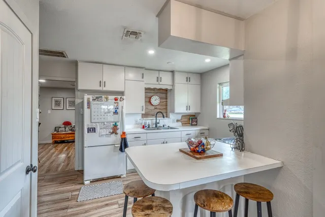 a view of a dining room and livingroom with furniture wooden floor and a chandelier