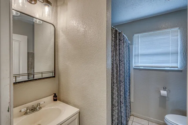 a bathroom with a sink and mirror with toilet