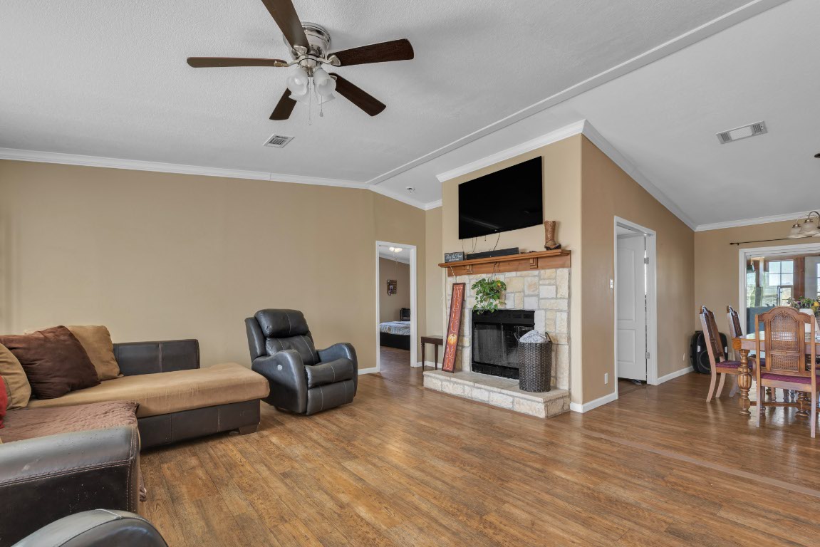 401 High Ridge Meadows Drive Gonzales, TX 78629 - Photo 11 of 31 a living room with furniture a fireplace and a flat screen tv