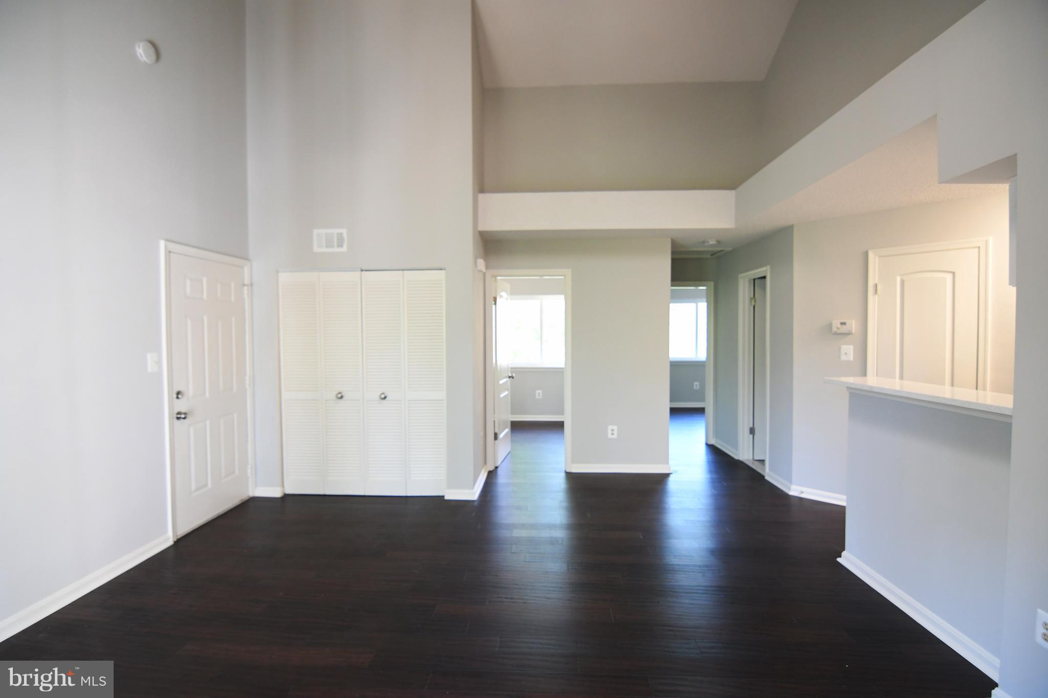 10803 Amherst Avenue, Unit F Silver Spring, MD 20902 - Photo 4 of 23 a view of an empty room with wooden floor and a window