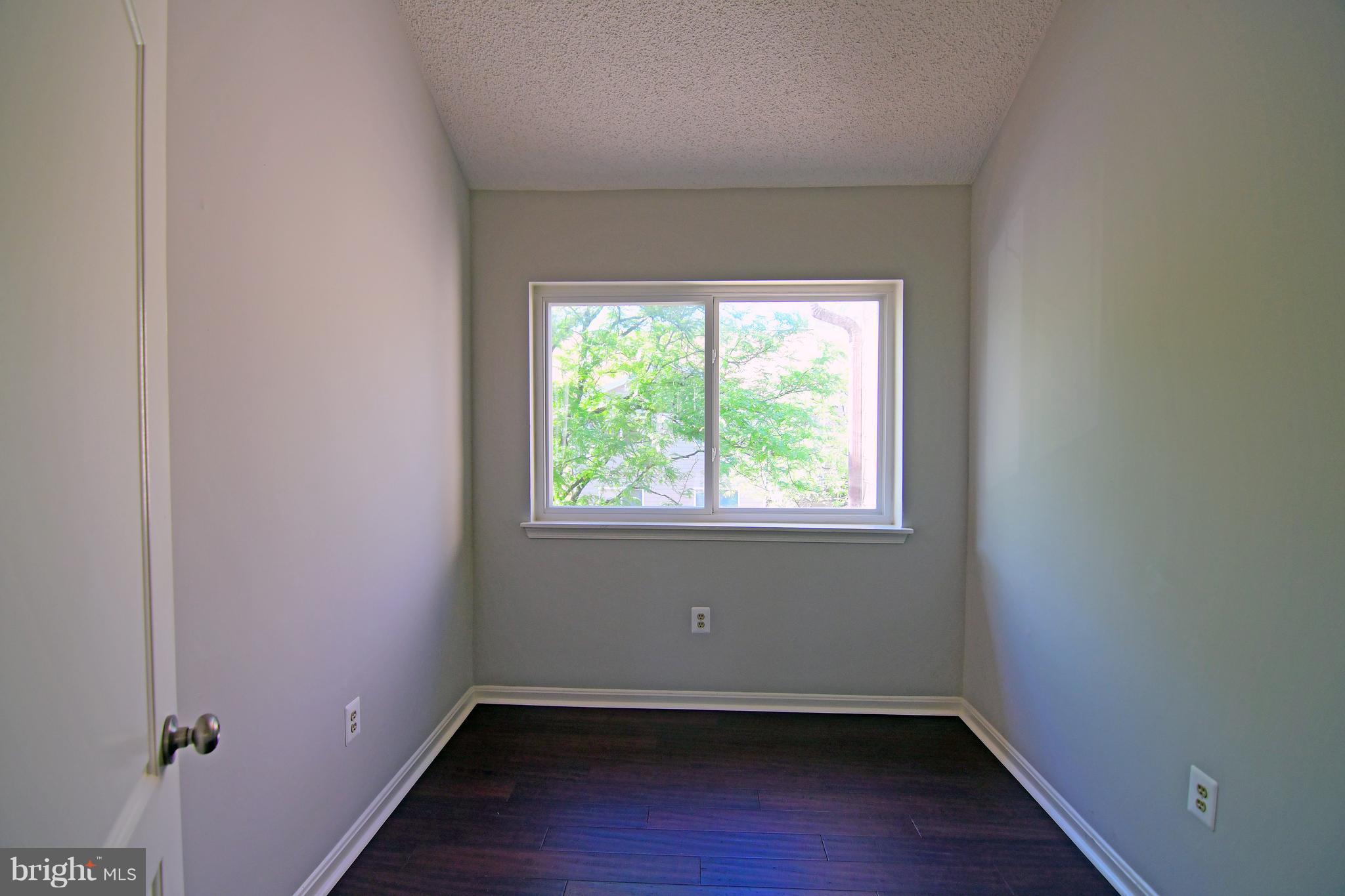 10803 Amherst Avenue, Unit F Silver Spring, MD 20902 - Photo 5 of 23 an empty room with wooden floor and windows