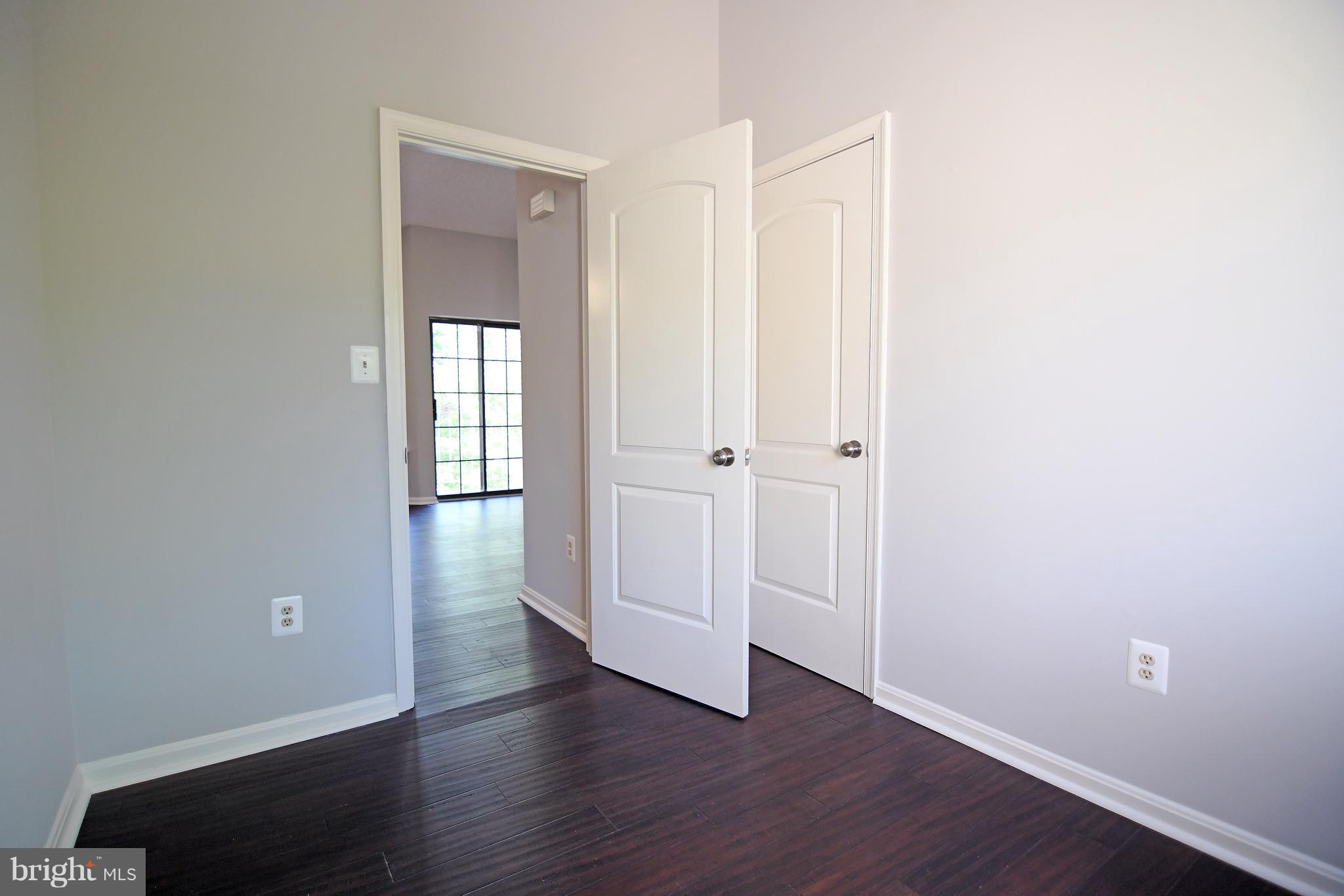 10803 Amherst Avenue, Unit F Silver Spring, MD 20902 - Photo 6 of 23 an empty room with wooden floor and closet