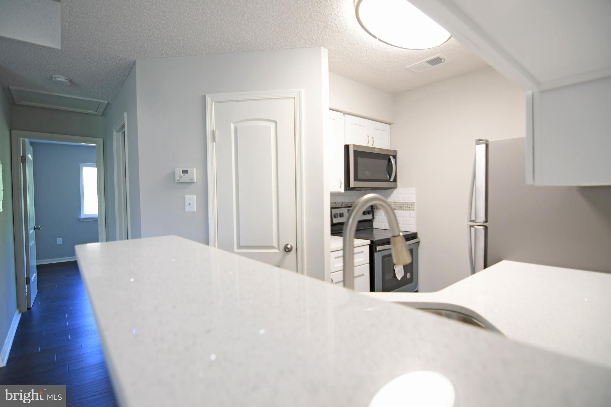 10803 Amherst Avenue, Unit F Silver Spring, MD 20902 - Photo 9 of 23 a bedroom with a bed and a flat screen tv