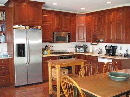 383 Rose Hill Road Water Mill, NY 11976 - Photo 9 of 13 a kitchen with stainless steel appliances granite countertop a refrigerator a sink a stove with wooden cabinets