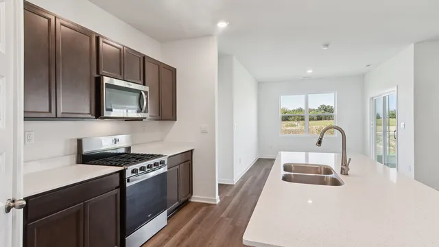 a kitchen with a sink a stove and microwave